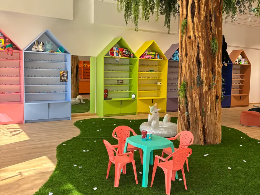 Les montures enfant rangées à hauteur d'enfant dans les maisons colorées.